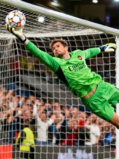 Goalkeeper making a spectacular diving save in a European football match.