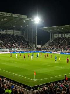 Electrifying atmosphere at a European derby match with fans cheering a dramatic late goal.