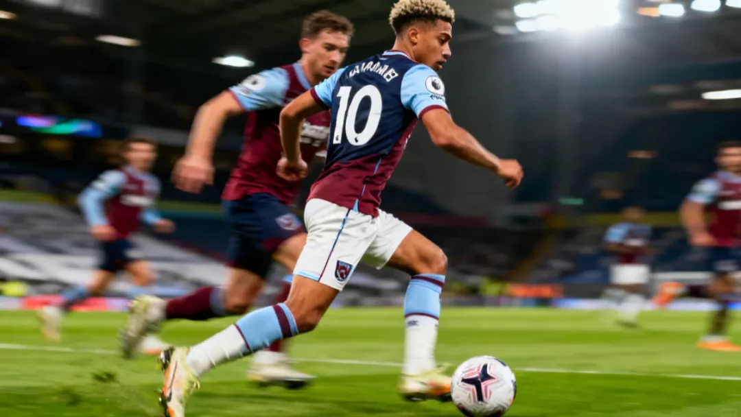 American midfielder dribbling past an opponent in a high-intensity Premier League match.