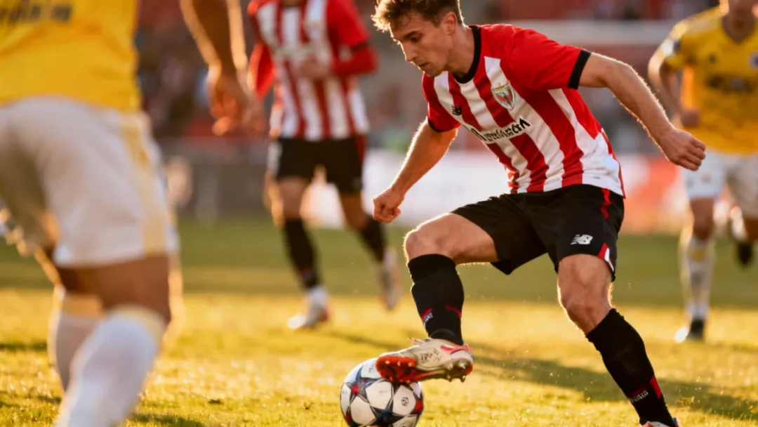 Midfielder demonstrating exceptional ball control during a European league match, highlighting technical prowess.