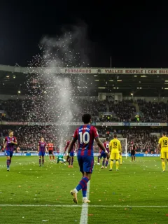 Dynamic football stadium scene with celebrating player and illuminated pitch.