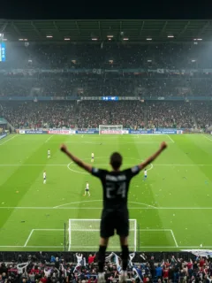 Football player celebrating goal in a packed stadium